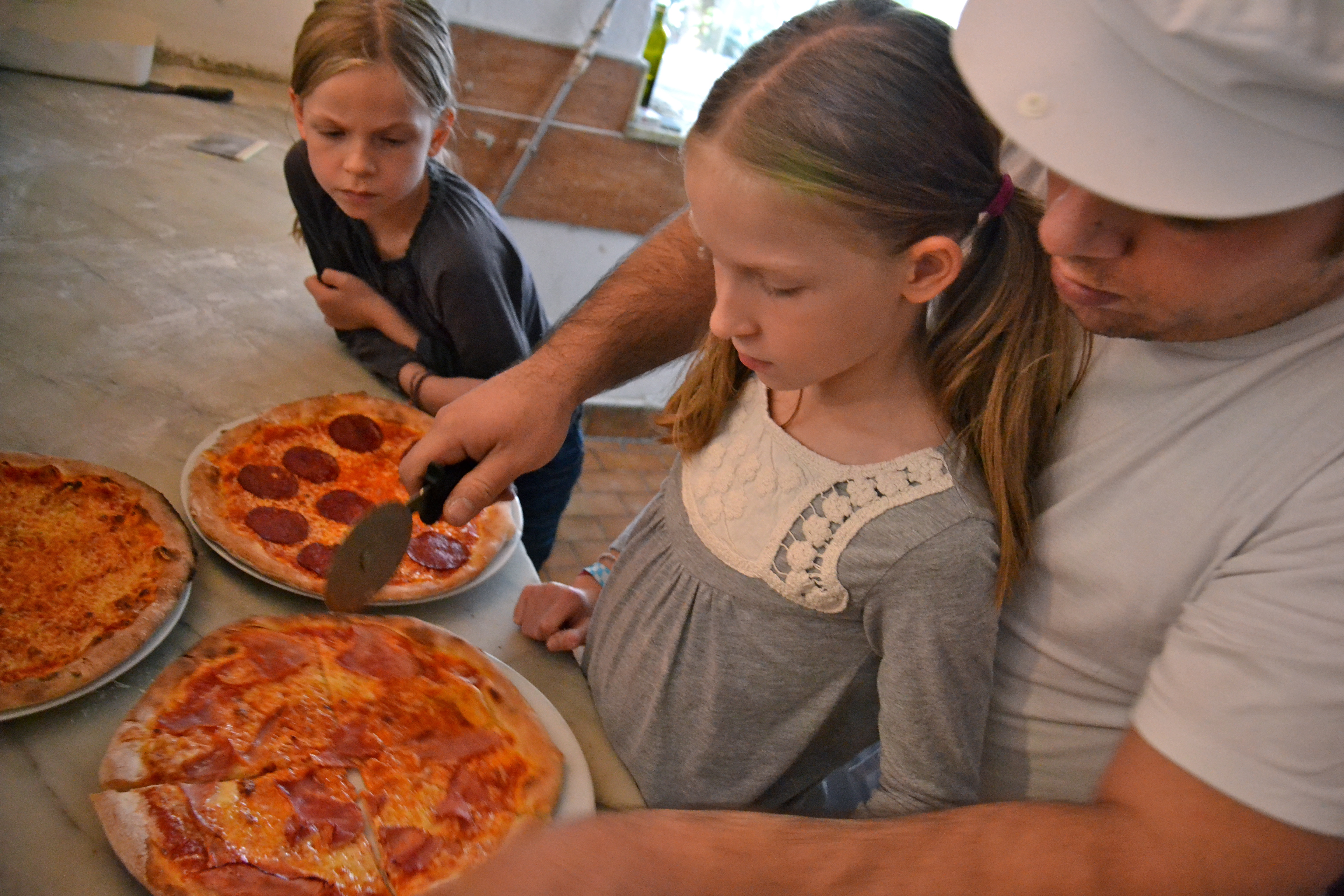 Kinderpizza - Francesco schneidet die Pizza in Stücke